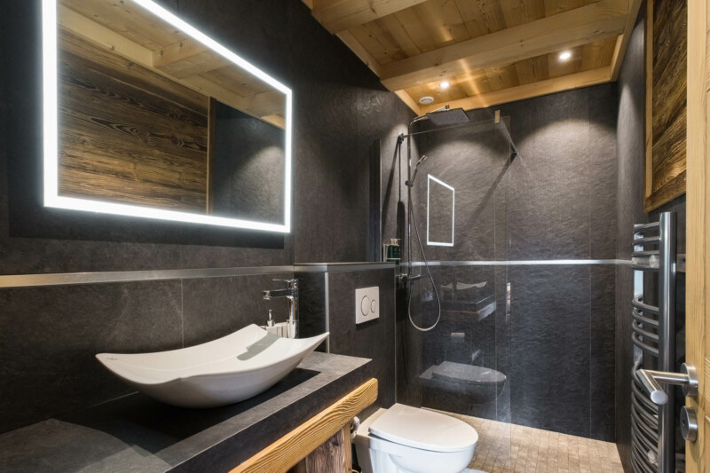 Photographe chalets de luxe en Haute Savoie : salle de bain aux tons contrastés dans les chalets Bovard
