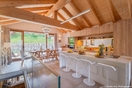 Photographe Chalet De Luxe Dans Les Alpes : La Salle à Manger Et Sa Grande Baie Vitrée