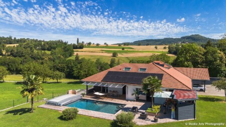 Photographe immobilier dans l’avant-pays savoyard : vue drone maison et piscine avec un beau ciel de traine