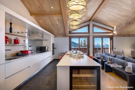 photographe immobilier de luxe à Courchevel : cuisine ouverte sur salon et vue montagne