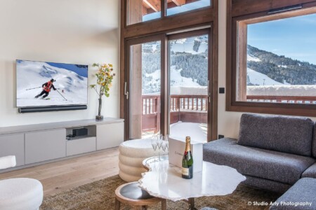 photographie agence immobilière de luxe : salon avec grande ouvertures sur le balcon et sa vue montagne