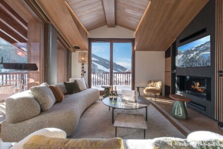 photographie agence immobilière dans les Alpes : salon cheminée et balcon vue montagne en panorama